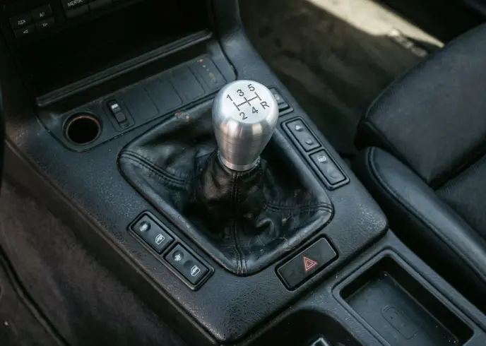 close-up of an aftermarket short throw shifter assembly installed in a street car center console